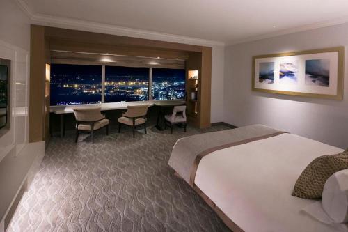 a hotel room with a large bed and a table with chairs at Yokohama Royal Park Hotel in Yokohama