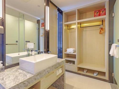 a bathroom with a large white sink and a tub at Echarm Hotel Taizhou International Convention and Exhibition Center 