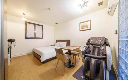 a hotel room with a bed and a table with a suitcase at Yongin Valentine in Yongin