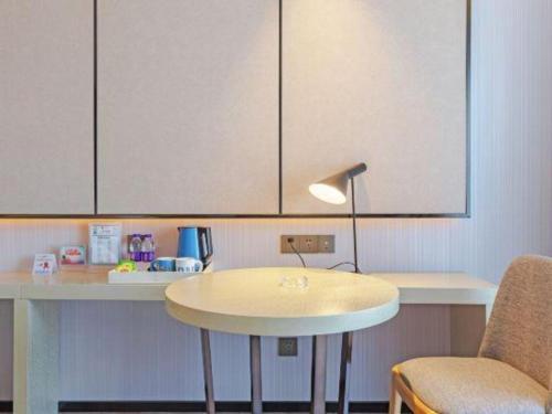 a kitchen with a table and a table and a lamp at Echarm Hotel Taizhou International Convention and Exhibition Center 
