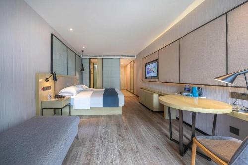 a hotel room with a bed and a desk at Echarm Hotel Taizhou International Convention and Exhibition Center 