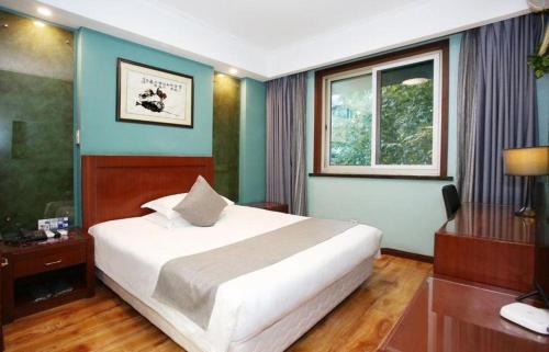 a bedroom with a large bed and a window at Hangzhou Bokai Westlake Hotel in Hangzhou
