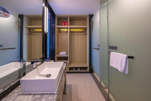 a bathroom with a tub and a sink and a shower at Echarm Hotel Taizhou International Convention and Exhibition Center 