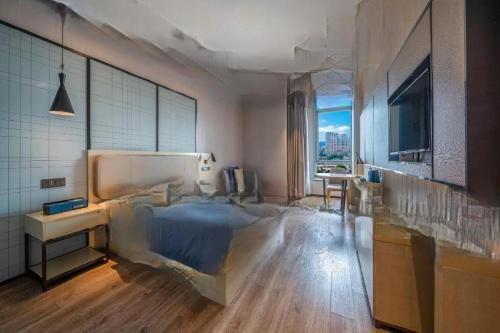 a bedroom with a bed and a desk and a window at Echarm Hotel Taizhou International Convention and Exhibition Center 