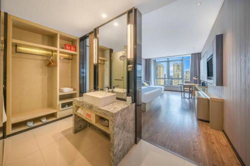 a large bathroom with a sink and a tub at Echarm Hotel Taizhou International Convention and Exhibition Center 