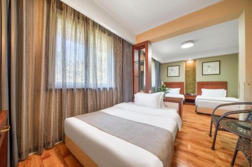 a hotel room with two beds and a table at Hangzhou Bokai Westlake Hotel in Hangzhou