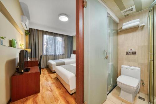a bathroom with two beds and a toilet and a shower at Hangzhou Bokai Westlake Hotel in Hangzhou