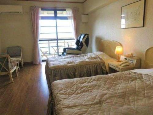 a hotel room with two beds and a window at Hotel Bellreef Otsuki in Otsuki