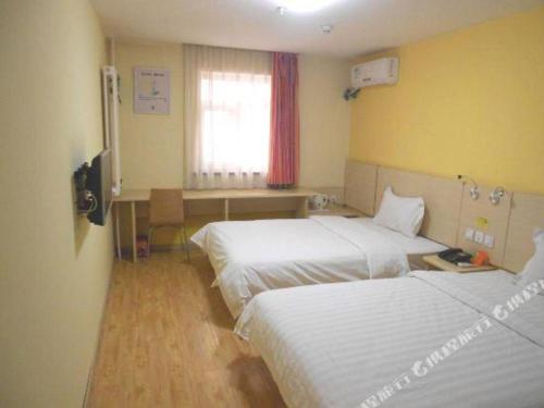 a hotel room with two beds and a desk at 7 Days Inn Baoding Railway Station in Baoding