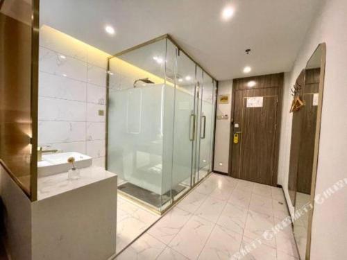 a bathroom with a glass shower and a sink at 7 Days Inn Xiangtan Erqiao Fenghuang East Road 1st County High School in Xiangtan