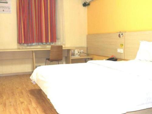 a hospital room with two beds and a table and a desk at 7 Days Inn Baoding Railway Station in Baoding