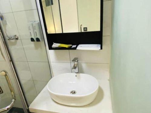 a bathroom with a white sink and a mirror at 7 Days Inn Baoding Railway Station in Baoding