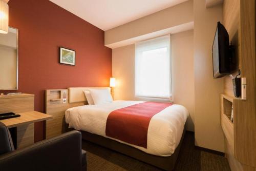 a hotel room with a bed and a window at KEIKYU EX INN Keikyu Kawasaki-Station in Kawasaki