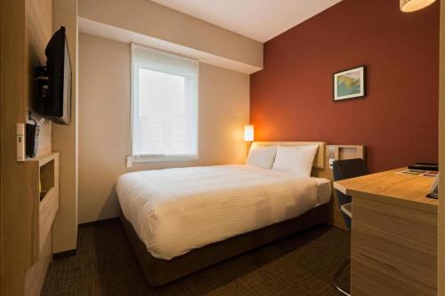 a hotel room with a bed and a window at KEIKYU EX INN Keikyu Kawasaki-Station in Kawasaki