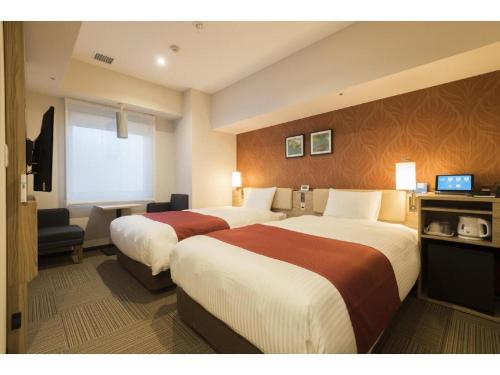 a hotel room with two beds and a television at KEIKYU EX INN Keikyu Kawasaki-Station in Kawasaki