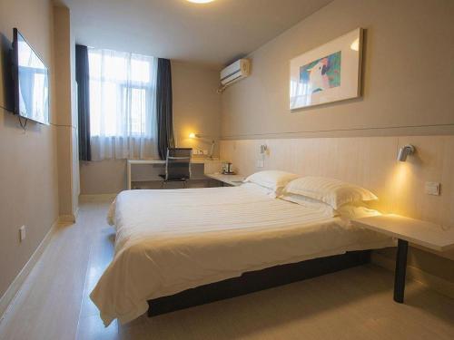 a bedroom with a large white bed in a room at Jinjiang Inn Yantai Fushan District Fuhai Road in Yantai