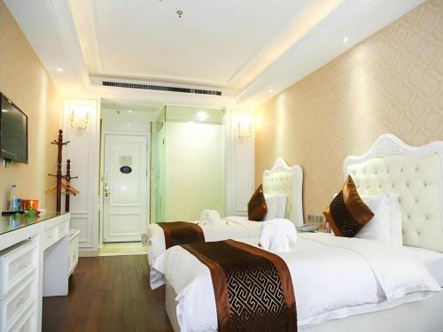 a bedroom with two beds and a television at GreenTree Alliance Anhui Hefei South Passenger Station South High Speed Railway Station Hotel in Hefei