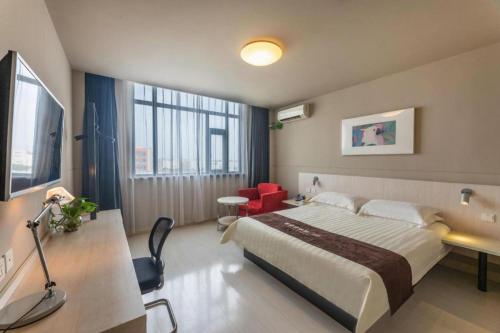 una camera d'albergo con un letto grande e una scrivania di Jinjiang Inn Tongli East China Commercial City a Suzhou