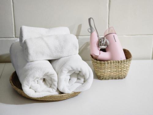 a pile of towels and a basket on a counter at 78's Hometel Pattaya 101 in Pattaya Central