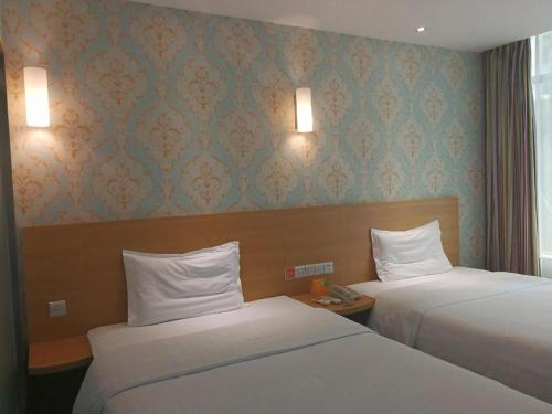 a hotel room with two beds and a window at 7 Days Inn Wuhan Hanyang Wanda Plaza in Wuhan