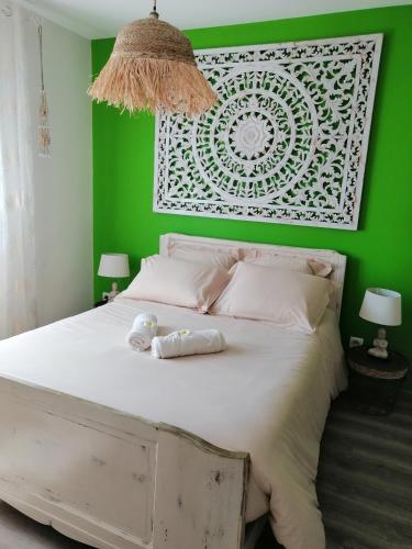 - une chambre verte avec un lit avec deux animaux rembourrés dans l'établissement La parenthèse, à Beaucaire