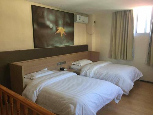 two beds in a hotel room with avertisement at 7 Days Inn Zhangjiakou Chongli Yuxing Road in Zhangjiakou