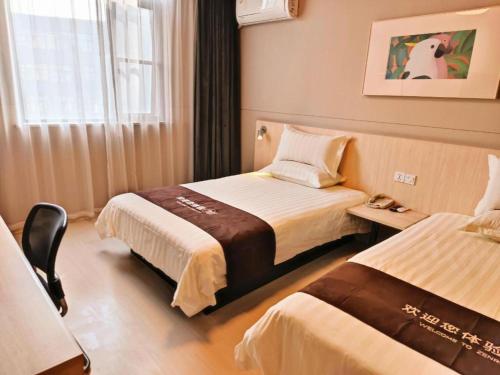 ein Hotelzimmer mit zwei Betten und einem Fenster in der Unterkunft Jinjiang Inn Bengbu Huaihe Road in Bengbu