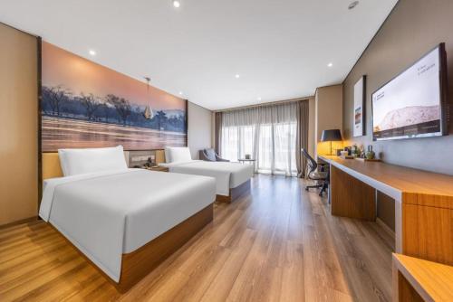 a hotel room with two beds and a desk at Atour Hotel Beijing West Railway Station South Square in Beijing