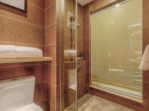a bathroom with a toilet and a glass shower at Atour Hotel Xi'an High Tech Dazhai Road in Xi'an