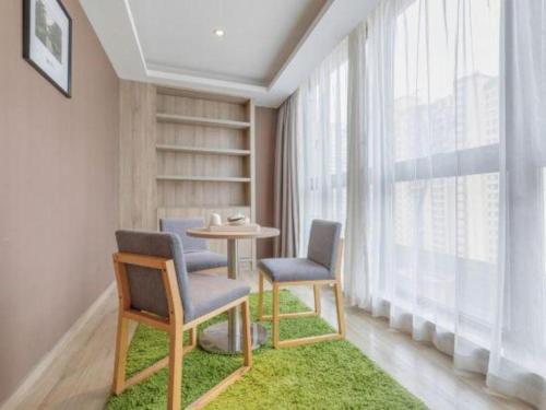a room with two chairs and a table and a window at Atour Hotel Xi'an High Tech Dazhai Road in Xi'an