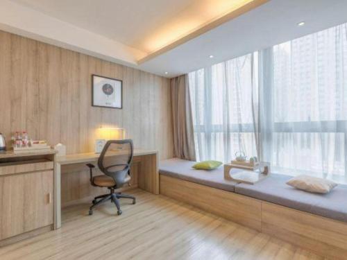 a room with a bed with a chair and a window at Atour Hotel Xi'an High Tech Dazhai Road in Xi'an