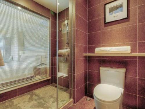 a bathroom with a toilet and a glass shower at Atour Hotel Xi'an High Tech Dazhai Road in Xi'an