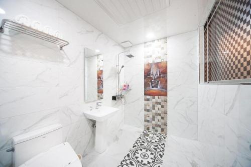 a white bathroom with a sink and a toilet at SH Hotel in Mokpo