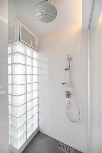 a white bathroom with a shower and a sink at Pure Sunset Beach - Ocean View Room, Pattaya in Na Jomtien
