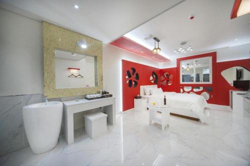 a bathroom with a white tub and a red wall at SH Hotel in Mokpo