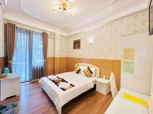Un dormitorio con una cama y un escritorio y una ventana. en Truc Huyen Hotel, en Ho Chi Minh