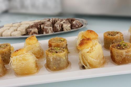 a plate of pastries on a table with a plate of desserts at Attalos Hotel in Athens