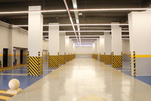 an empty parking garage with yellow and black and white columns at Gorash Hotel in Khamis Mushayt