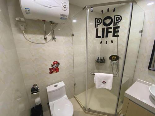 a small bathroom with a shower and a toilet at Imin Hotel in Huadu