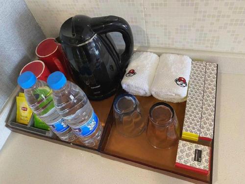 a tray with water bottles and towels and a tea kettle at Imin Hotel in Huadu