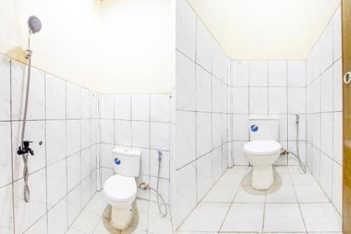 a bathroom with two toilets and a shower at Hotel O Ekslusive Double'n in Solo
