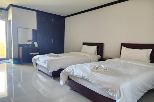 a bedroom with two beds with white sheets at ONE Residence in Pathum Thani