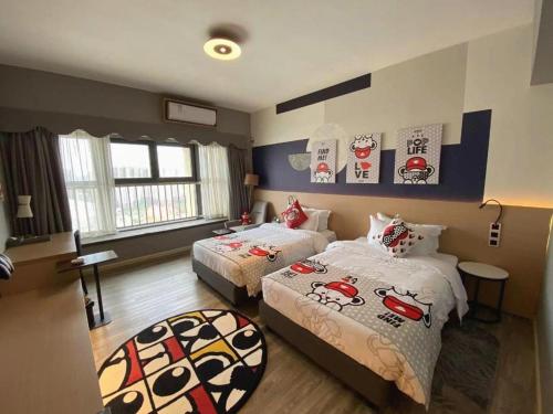 a bedroom with two beds with hello kitty sheets at Imin Hotel in Huadu