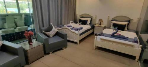 a living room with two beds and a chair at Crystal Palace Hotel in Port Vila