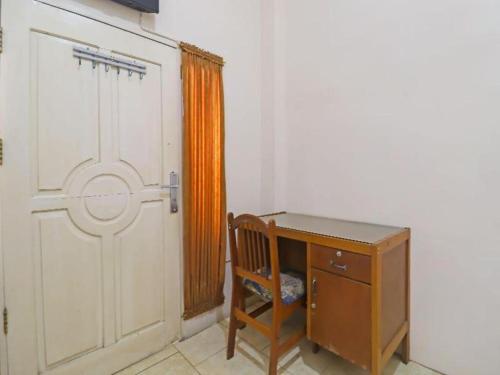 a room with a door and a desk and a crib at OYO 2899 Ardilia Bandara Syariah in Jambi