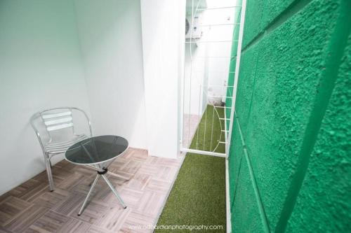 a room with a chair and a green wall at Smart Budget Hotel in Semarang