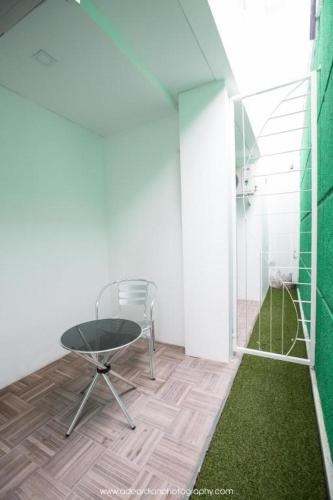 a table and chair in a room with a green wall at Smart Budget Hotel in Semarang