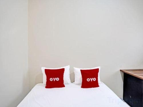 a bedroom with two red pillows on a bed at Hotel O Wonoayu Residence Syariah in Sidoarjo