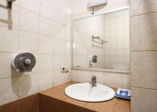 a bathroom with a sink and a mirror at Hotel Permata Bandara in Jakarta