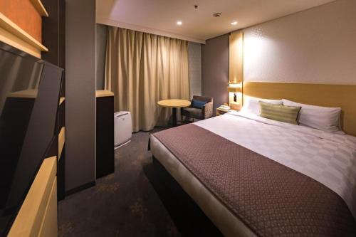 a hotel room with a bed and a table at Nagoya Sakae Tokyu REI Hotel in Nagoya